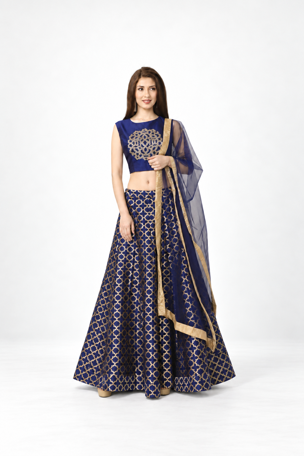 Full-length portrait of a smiling model wearing a navy and gold lehenga with a sheer dupatta