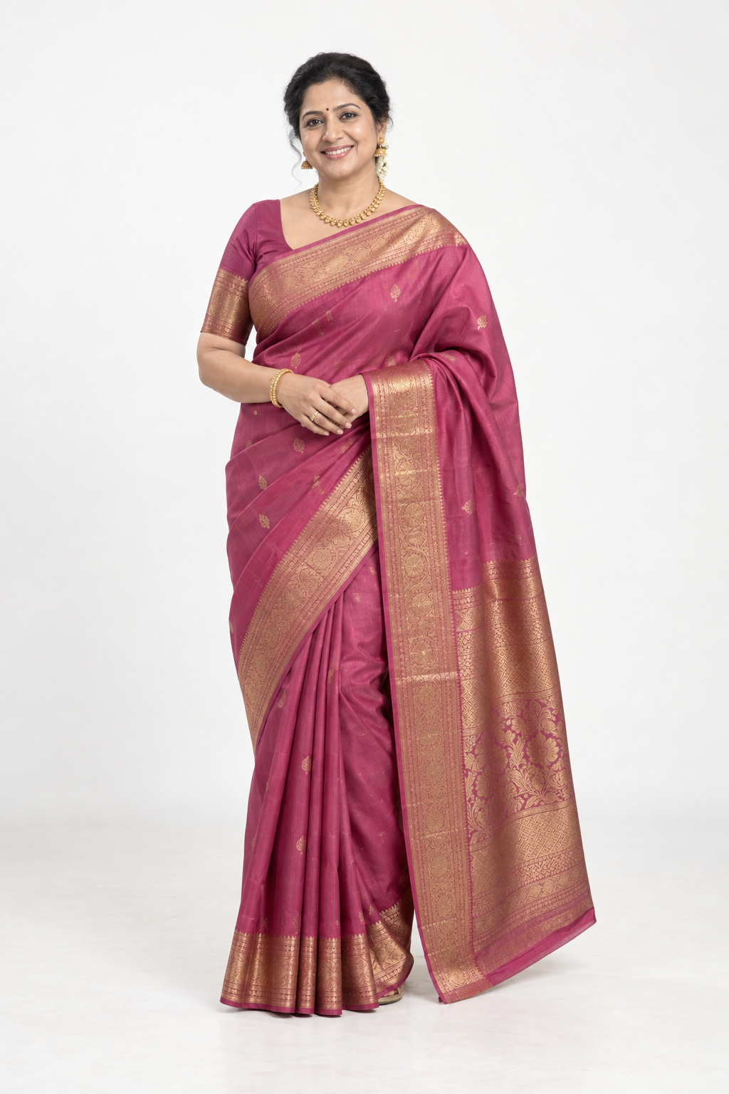 Smiling model in a rose saree with a gold border and pallu, shown in full length